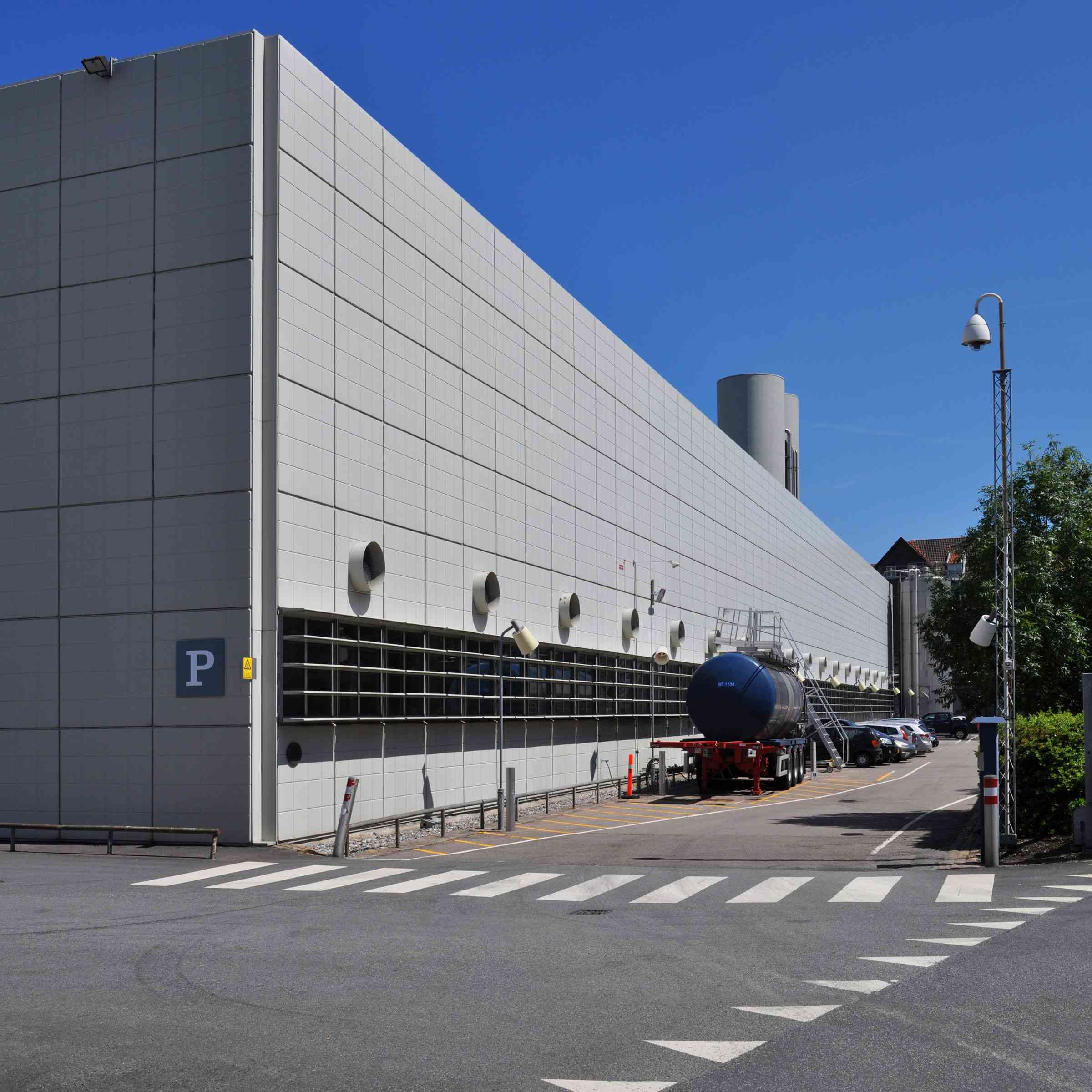 A long commercial building clad in pale composite panels