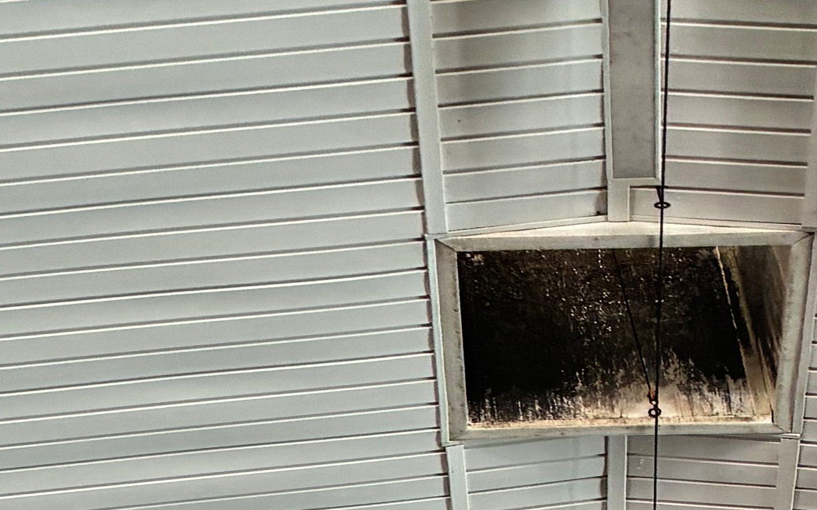 The same ceiling at 11:21 am the same morning, after washing: the ribbed liner, the ridge trim and the vent-box rim are clean white.