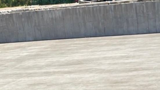 After: the same end wall and pit floor washed back to clean grey concrete.